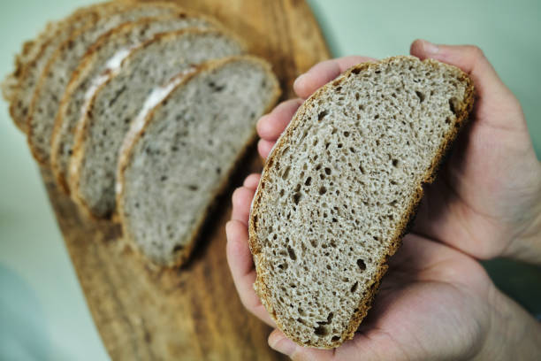 istock baker holding whole wheat bread, which is cut out 1481137840