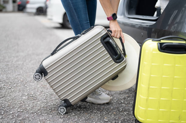 istock A woman is pulling heavy luggage into the car boot 1481140942