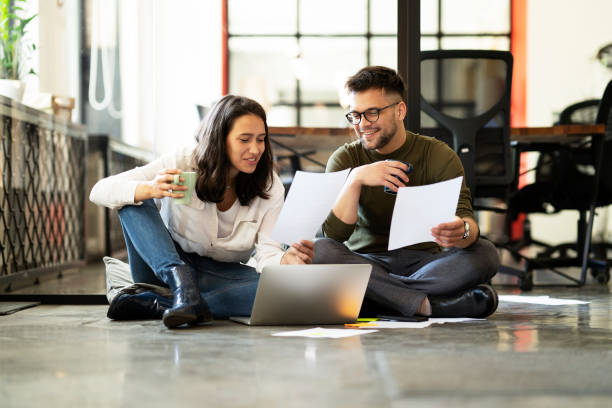 istock Colleagues sitting on the floor in office. 1481143086