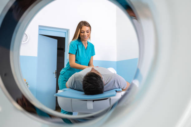 istock Female Doctor Looking At Patient Undergoing CT Scan. Doctor in uniform using tomography machine with lying patient in hospital 1481143717