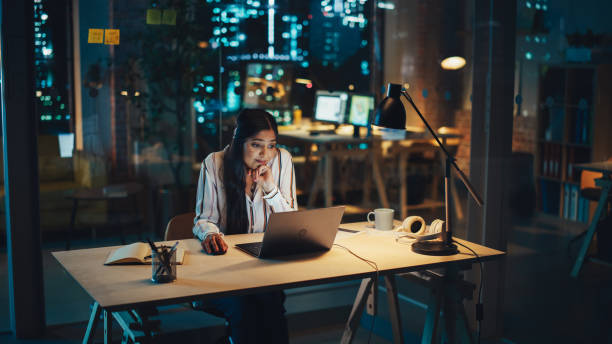istock Creative Multiethnic Female Working on Laptop Computer in a Company Office at Night. Surprised Project Manager Receiving an Email, Browsing Internet, Working On a Corporate Strategy. 1481144995