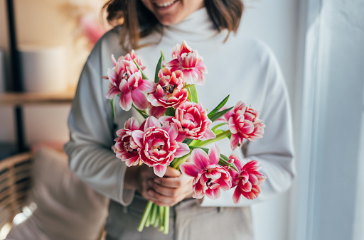 Woman holding a bouquet of pink tulips