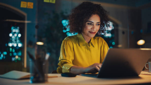 istock Expressive Multiethnic Middle Eastern Female Working on a Creative Job Position in a Business Agency. Happy Project Manager Browsing Internet, Keeping Important Notes in Notebook. Evening at Work. 1481145799