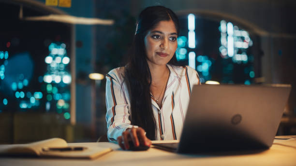 istock Indian Female Working in Creative Agency in the Evening, Implementing Modern Business Strategy for Clients. Successful Specialist Using Laptop Computer for Serious Work. 1481145887