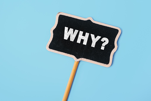 Why - word on a small chalkboard on a blue background. Top view. Business answer and analysis, problem ask, interrogation, research information concept