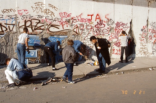 Berlin Mitte, Germany, 1990. Tourists and souvenir hunters use hammers and chisels to hew pieces out of the Berlin Wall.
