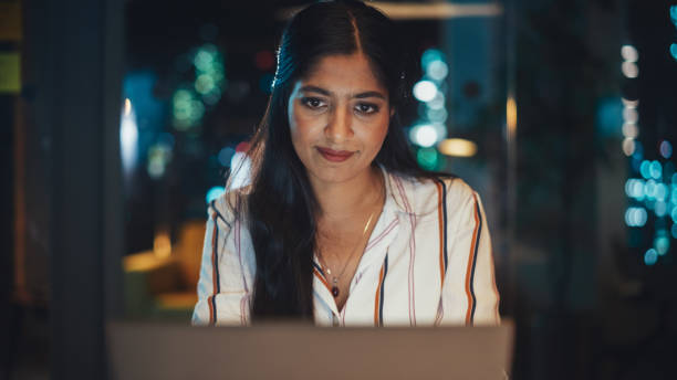 istock Young Diverse Accountant Working in the Office Late in the Evening. Positive Female Using Laptop Computer, Preparing Job Assignment and Corporate Report for Finance Director. 1481147010
