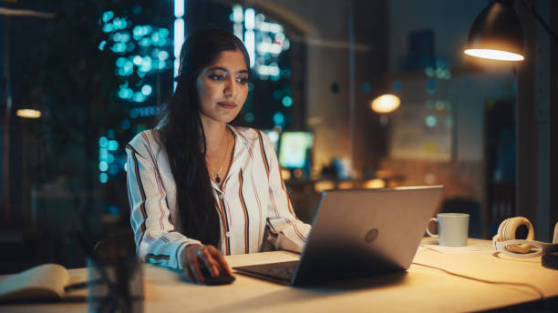 istock Young Diverse Accountant Working in the Office Late in the Evening. Positive Female Using Laptop Computer, Preparing Job Assignment and Corporate Report for Finance Director. 1481147016