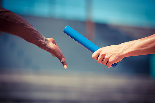 Passing the Relay Baton Passing the Relay Baton passing giving photos stock pictures, royalty-free photos & images