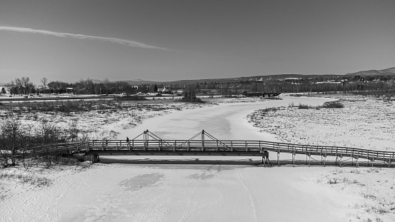 View of a large river with bridge in the Canadian forest in winter