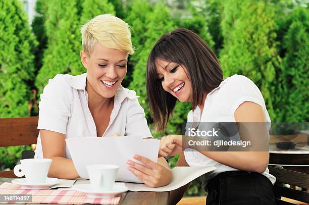 Two Businesswoman Reading Documents Stock Photo - Download Image Now - 20-24 Years, 20-29 Years, Adult