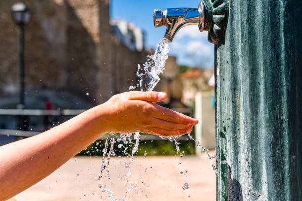 istock Hand paying with water flowing from city fountain 1481149996