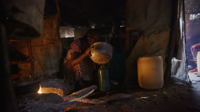 SLO MO Samburu woman cook inside of her tribal hut - Samburu Tribe