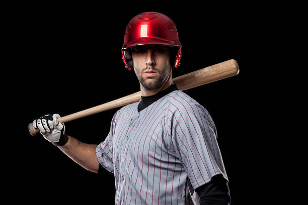 istock Baseball player holding bat with black background 148115107