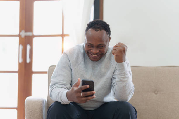 istock Young african american man using mobile cell phone hold credit bank card. banking application, online shopping concept 1481152849