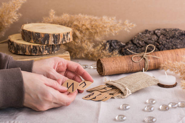 istock Women's hands are sorting through the Scandinavian divination runes on the table 1481160489