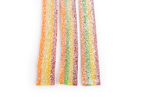 Multicolor gummy candy sweets on white background. Colored marmalade in the sugar on the yellow background. Natural rainbow colored marmalade candy. Liquorice candy