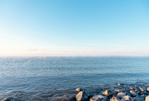 Rock beach, sea, and cloudy blue sky  on the sunny day