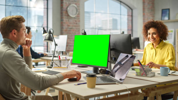 istock Multiethnic Group of Creative Colleagues Working on Computers in a Modern Bright Office. Male Administrator Preparing a Presentation Using Green Screen. Biracial Businesswoman Smiling. 1481163880