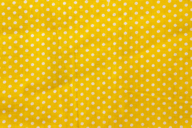 Yellow and white polka dot cotton texture, fabric textile background