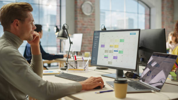 istock Portrait of White Creative Young Man With Glasses Working on a Computer During Day Time in a Spacious Modern Office. Male Graphic Designer Smiling While Developing a New Visual Concept for Website. 1481165471