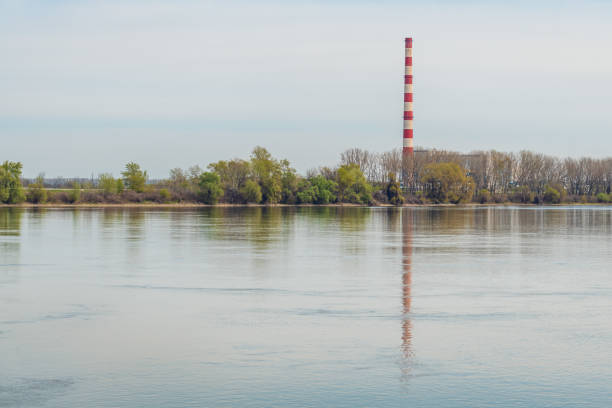 Heating plant and thermal power station chimney, industrial building by the river
