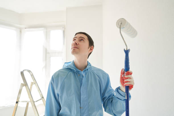 istock Man stand in the room with paint roller in his hand 1481167041