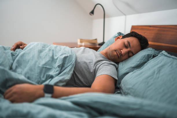 istock Asian Man Sleeping in Bed Wearing a Watch 1481168537