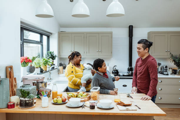istock Multiethnic family at home preparing breakfast. Step-father talking to the boy while mom is playing with baby 1481174676