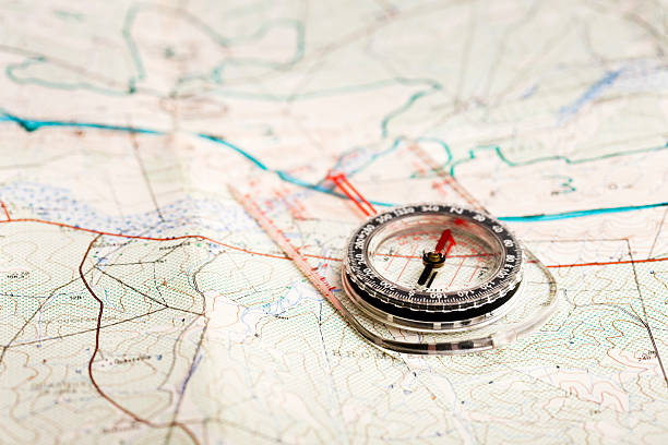 Finding the way Compass and topographical map to chart your way through the great outdoors. Camera: Canon EOS 1Ds Mark III. orienteering stock pictures, royalty-free photos & images