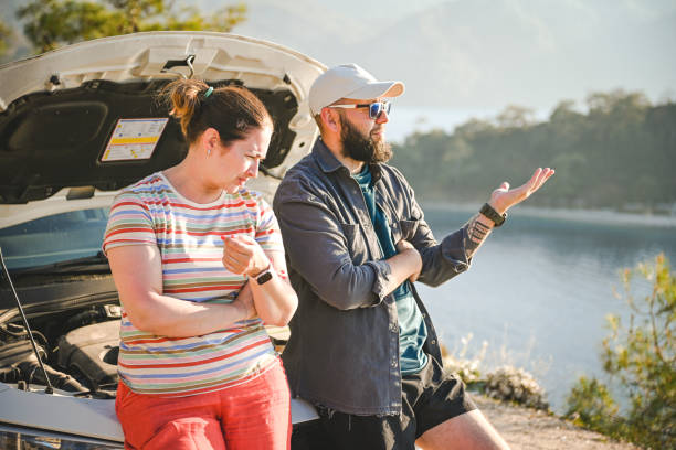 casal viajante discutindo perto de um carro quebrado - stranded travel people traveling disappointment - fotografias e filmes do acervo