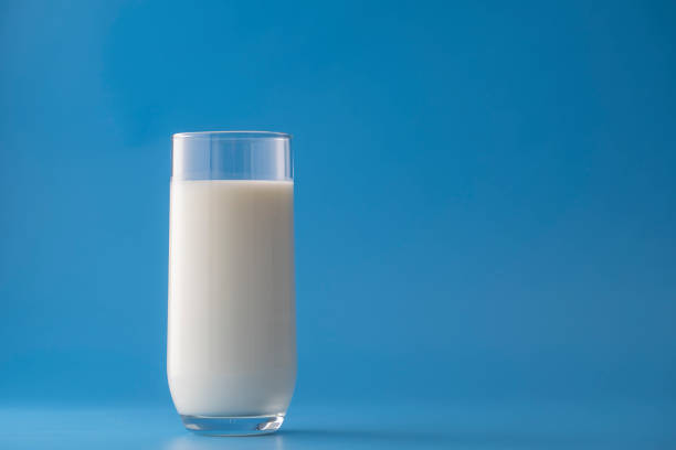 istock Glass of white milk isolated on blue background 1481180979