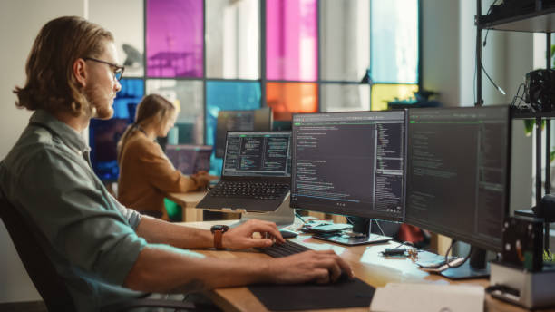 istock Caucasian Man Coding on Personal Computer and Laptop Set Up In Stylish Office. Professional Programmer Developing Innovative AI Software in Technological Start-Up, Using Multiple Displays. 1481181884