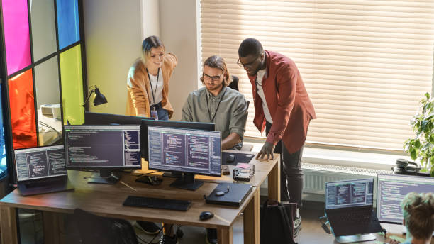 istock Male CEO and Female CTO Talking to Software Engineer Team Lead In Creative Office Space. Black Entrepreneur and Caucasian Business Partner Offering New Features For Their Innovative Online Service. 1481183172