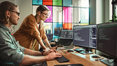 Male Data Scientist and Female Developer Working With Errors in Code on Desktop Computer in Creative Office. Caucasian Man and Woman Succesfully Fixed a Software Bug And High Five Each Other.