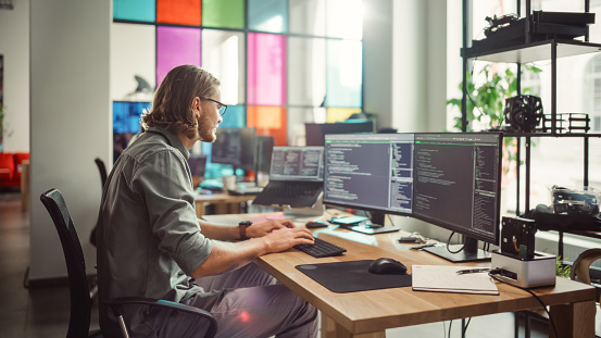 Professional Male Programmer Writing Code On Desktop Computer With ...
