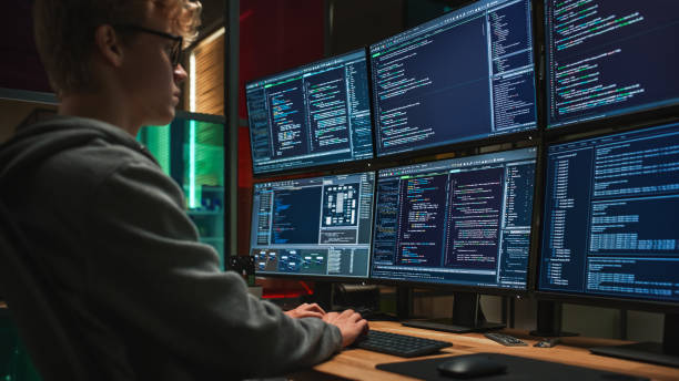 istock Young Caucasian Man Writing Code on Professional Six Monitors Setup in Dark Office. Male Cyber Security Specialist Controlling Digital Data Protection System For International SAAS Firm 1481183757