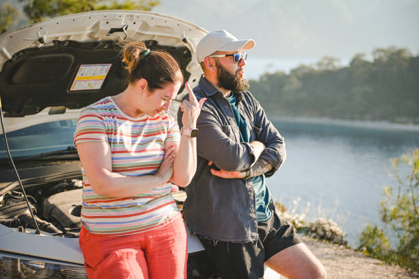 casal viajante discutindo perto de um carro quebrado - stranded travel people traveling disappointment - fotografias e filmes do acervo