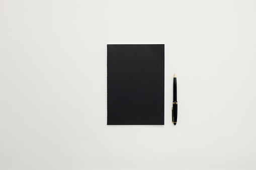Black personal organiser and a pen background for design use