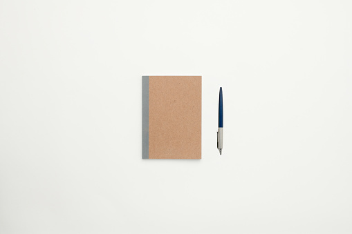 Brown personal organiser and a pen background for design use