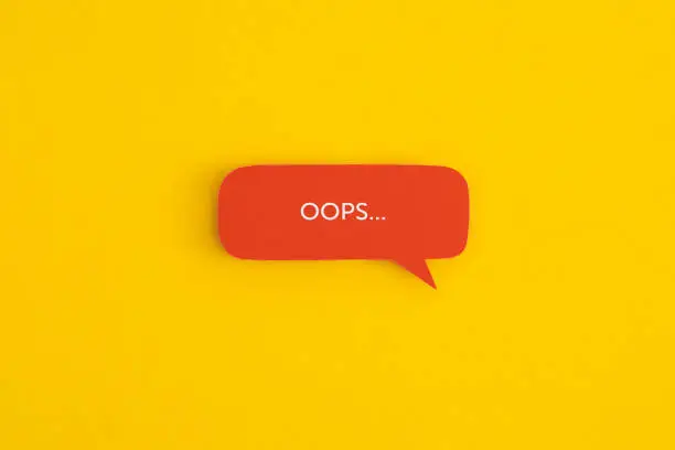 Paper speech bubble with the word "OOPS" on a yellow background. Top view with copy space. Flat lay.