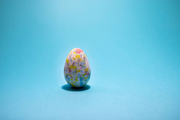 Easter colorful egg on turquoise blue background minimalistic