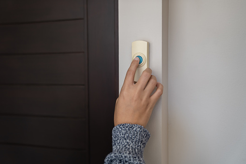 close-up finger pressing doorbell