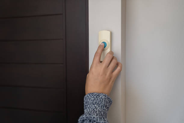close-up finger pressing doorbell stock photo
