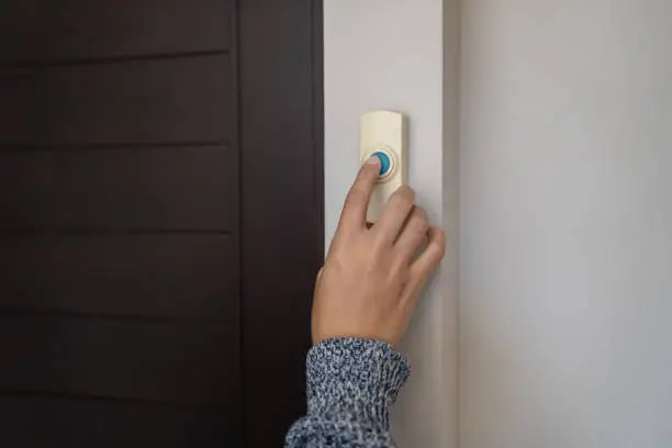 close-up finger pressing doorbell