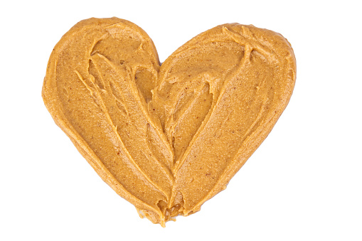 Homemade peanut butter and patterned sandwich isolated on white background. The concept of love for nuts. Favorite breakfast. Nuts in the shape of a heart