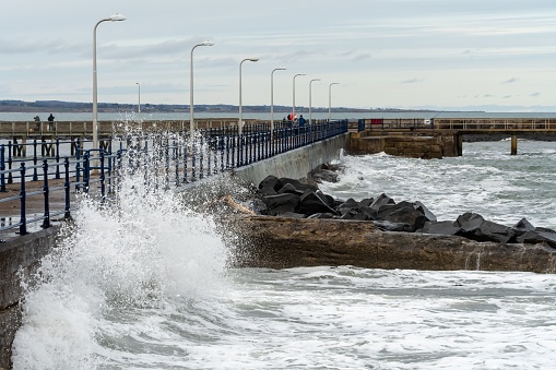 Close up of waves crashing at the harbour wall in Amble, Northumberland, UK