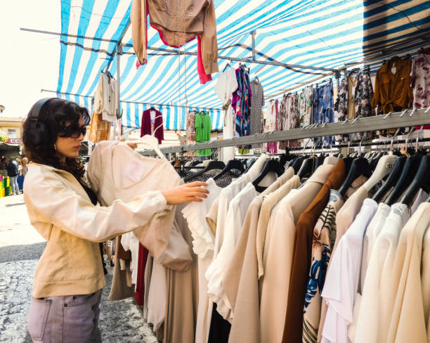 istock Young girl choosing clothes in a second hand market 1481199298