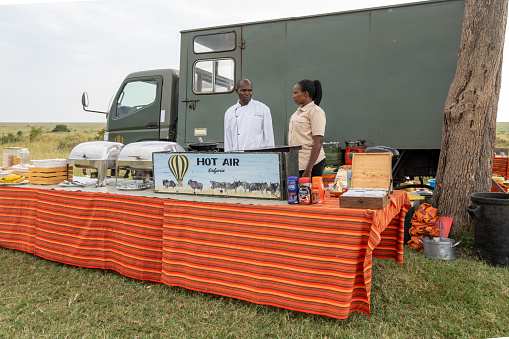 Kenya, Africa - March 10, 2023: African bush breakfast buffet set up after a hot air balloon safari in the Masai Mara Reserve