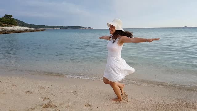 Young Woman Spinning Around On The Beach In Thasos